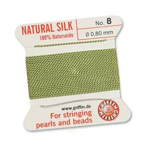 May include: A spool of natural silk thread, labeled "NATURAL SILK" and "100% Naturseide." The thread is a light green color, with a diameter of 0.80 mm. The label also includes the text "For stringing pearls and beads" and the website www.griffin.de.