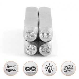May include: Metal stamps with various designs, including a flower, infinity symbol, lightbulb, and the word "AND." The set also includes stamps that read "hand made." These tools are likely used for crafting or jewelry making.