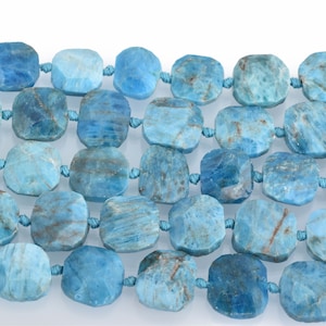 May include: A strand of blue apatite beads, each bead is faceted and has a square shape. The beads are strung on a cord with knots between each bead.