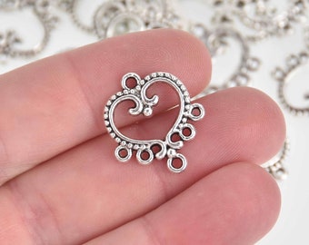 Può includere: Ciondolo a forma di cuore in argento con dettagli intricati e più anelli per attaccare i fermagli dei gioielli.