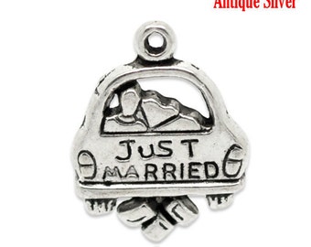 May include: Antique silver charm in the shape of a car with the words "Just Married" engraved on it. The car has a couple inside and a floral design at the bottom. The charm has a loop at the top for attaching to a necklace or bracelet.