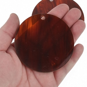 May include: Two round, brown, marbled, plastic discs with a hole in the center.