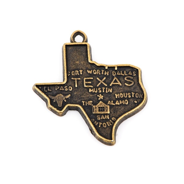 May include: A gold-toned metal charm shaped like the state of Texas. The charm features the words "Texas", "Fort Worth", "Dallas", "El Paso", "Austin", "Houston", "The Alamo", and "San Antonio".