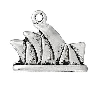 May include: Silver charm shaped like the Sydney Opera House. The charm has a loop at the top for attaching to a necklace or bracelet.