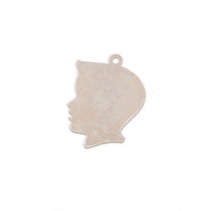 May include: Silver charm in the shape of a person's profile. The charm is a silhouette of a person's head and shoulders.