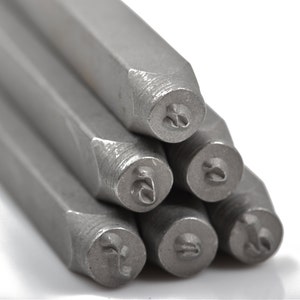 May include: Close-up of a set of metal letter stamps. The stamps are silver and have a hexagonal shape with a circular stamp head. The heads have the letter "2" stamped on them. The background is white.