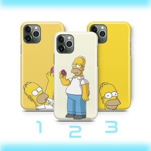 May include: Three phone cases featuring Homer Simpson. The center case shows Homer holding a donut. The other two cases are yellow with Homer Simpson graphics. The numbers 1, 2, and 3 are below the cases.