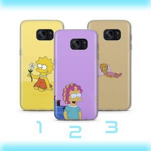 Peut inclure: Trois coques de téléphone avec des personnages des Simpson. Les coques sont jaunes, violettes et beiges, chacune avec une illustration de personnage différente. Les coques sont numérotées 1, 2 et 3 en bas.