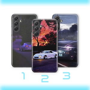 Könnte beinhalten: Drei Handyhüllen mit Auto-Designs. Die Hüllen zeigen Bilder eines weißen Sportwagens, eines lila Sportwagens und eines dunkelgrünen Sportwagens auf einer Straße. Der Hintergrund umfasst einen Sonnenuntergang, Bäume und eine Straße.