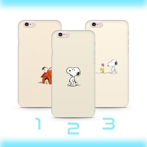 May include: Three beige phone cases featuring Snoopy from Peanuts. Each case has a different black and white illustration of Snoopy. The cases are numbered 1, 2, and 3.