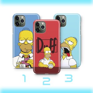 Peut inclure: Trois coques de téléphone avec le personnage de dessin animé Homer Simpson. Les coques sont bleues et rouges, avec Homer dans différentes poses. Une coque porte le logo de la bière Duff. Les coques sont numérotées 1, 2 et 3.