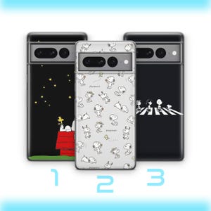 Puede incluir: Tres fundas de teléfono con diferentes diseños. Una funda presenta a Snoopy en su caseta bajo un cielo estrellado. Otra tiene un patrón de personajes de Snoopy. La tercera funda muestra a Snoopy y sus amigos cruzando una calle.