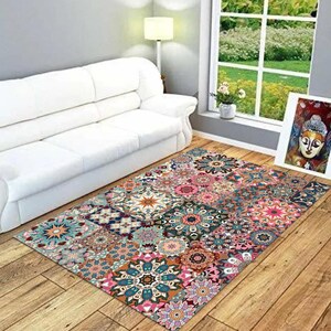 May include: A rectangular rug with a patchwork design. It features floral and geometric patterns in pink, teal, orange, and brown. The rug is on a wooden floor, with a white sofa and a window in the background. The rug's dimensions are approximately 200cm x 150cm.