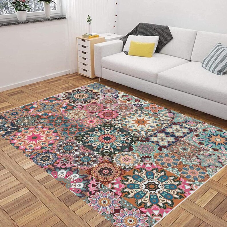 May include: A rectangular rug with a patchwork design featuring mandala patterns in pink, teal, orange, and brown. The rug is placed on a wooden floor, adding a bohemian style to the living space. The rug's dimensions are in centimetres.