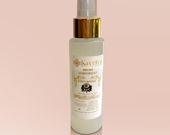 May include: A clear glass body spray bottle with a gold-colored cap and pump. The label reads "Kavelya Brume Corporelle Coco Rouge". The bottle is filled with a light-colored liquid and is set against a soft pink background.