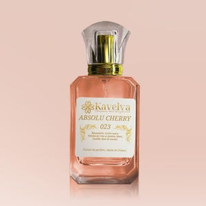 Peut inclure: Un flacon de parfum rectangulaire rose avec un bouchon transparent et doré. Il porte une étiquette blanche avec le texte "Kavelva ABSOLU CHERRY 023". Fabriqué en France, ce parfum est présenté dans un flacon élégant.