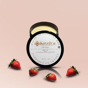 Könnte beinhalten: Ein schwarz-weißes Glas "Baume Déodorant Bio" mit dem Markennamen "Kavelva" und dem Wort "Fraise" wird angezeigt. Das Glas ist geöffnet und zeigt einen gelben Balsam. Vier frische Erdbeeren sind um das Glas herum verstreut.
