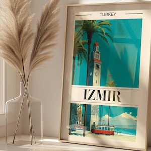 May include: Framed travel poster of Izmir, Turkey, featuring a turquoise background with a clock tower and palm trees. The poster also shows a red tram and the text "IZMIR". The frame is a light beige color.