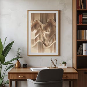 May include: A framed artwork featuring a light brown, wave-like relief sculpture. The artwork is in a gold frame and hangs on a white wall. The image is part of a home office setup, with a wooden desk, a gray chair, and a bookshelf.