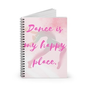 May include: Spiral-bound notebook with a pink cover. It features a dancer silhouette and the text "Dance is my happy place" in a bright pink font. The background has a watercolor effect with pink and white hues.