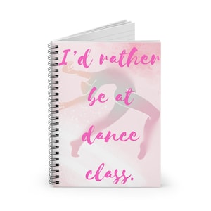 May include: A spiral-bound notebook with a pink cover. The cover has the text "I'd rather be at dance class" and a dancer silhouette. The background has a soft, watercolour effect.