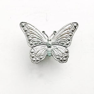 May include: Silver butterfly-shaped drawer pull with an ornate design.