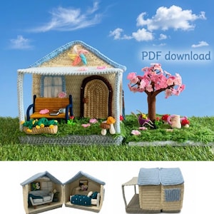 May include: A crocheted miniature house with a blue roof, beige walls, and a brown arched door. A bench, flowers, and a tree are also crocheted. The text "PDF download" is visible. The scene is set on a green, grassy base.