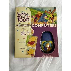 May include: A Disney Winnie the Pooh Cool Stuff for Computers set in its original packaging. The box features illustrations of Pooh, Piglet, Eeyore, and Tigger. It includes a yellow and blue computer mouse, a mouse pad, and a CD wallet.
