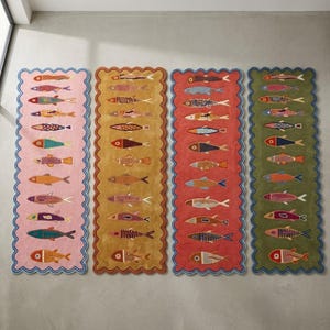 Peut inclure: Quatre tapis de couloir rectangulaires aux bords festonnés, chacun présentant une colonne verticale de poissons stylisés aux motifs et couleurs variés. Les tapis sont rose, jaune moutarde, rouge et vert olive, avec des bordures contrastées.