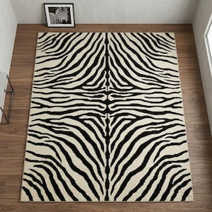 Op de afbeelding: Een rechthoekig vloerkleed met een contrastrijk zwart-wit zebrastrepenpatroon. Het ontwerp bestaat uit organische, vloeiende lijnen die vanuit het midden naar buiten toe spiegelen, wat zorgt voor een symmetrische dierenprint.