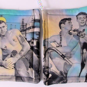 May include: Two vintage-style pot holders with a blue and green border. One features a man with tattoos and a yellow hat, the other features two men with a snake.