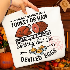 Puede incluir: Una camiseta blanca con texto negro que dice I WOULDN'T DO MUCH FOR TURKEY OR HAM BUT I WOULD DO SOME Sketchy Shit For DEVILED EGGS. El diseño incluye ilustraciones de un pavo asado, un jamón y tres huevos rellenos.