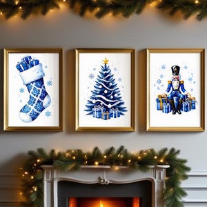 May include: Three framed watercolor prints with gold frames, depicting Christmas themes. The prints feature a blue stocking, a Christmas tree, and a nutcracker soldier. The artwork is set against a gray wall, with a fireplace and garland.