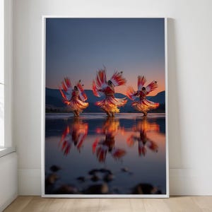 May include: A framed print featuring three dancers in vibrant red and orange costumes performing on water at sunset. The dancers' reflections mirror their movements, set against a backdrop of mountains and a twilight sky.