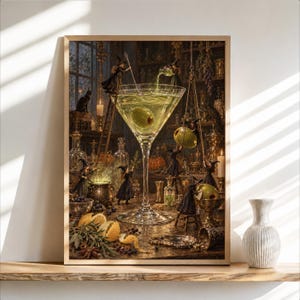 May include: A framed wall art print depicting a large martini glass filled with a pale green liquid and an olive. Tiny witches in black robes are shown interacting with the glass, a cauldron, and various apothecary bottles in a dark room.