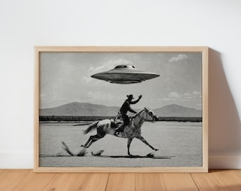 May include: A black and white framed print depicting a person in a cowboy hat riding a horse across a flat, dusty landscape. Above the rider, a large, metallic, disc-shaped unidentified flying object hovers in a cloudy sky over distant mountains.