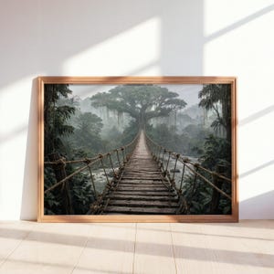May include: A rectangular wall art print in a light wood frame depicting a wooden rope suspension bridge stretching over a flowing river toward a large, ancient tree in a dense, misty, green tropical jungle landscape with hanging vines.