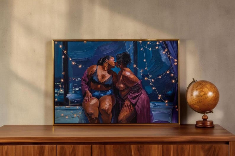 a painting of two women sitting together, with one woman appearing to kiss the other. The painting is framed and displayed on a wooden shelf or cabinet.