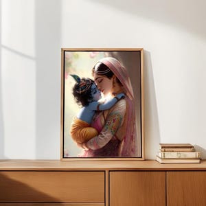 A framed painting of a woman embracing a child is displayed on a wooden cabinet against a white wall.