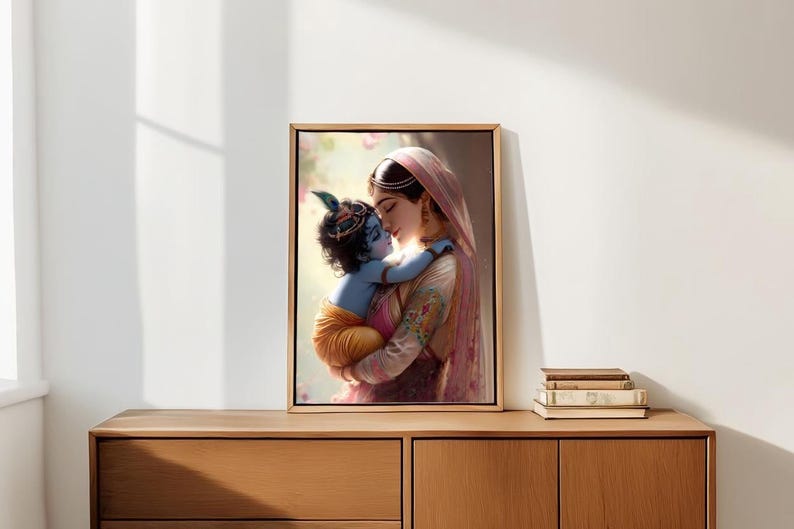A framed painting of a woman embracing a child is displayed on a wooden cabinet against a white wall.
