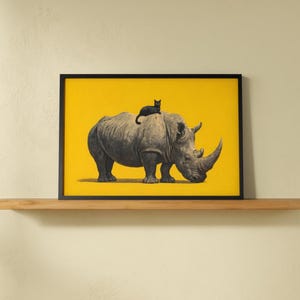 May include: A rectangular framed wall art print featuring a detailed illustration of a large gray rhinoceros standing in profile on a solid bright yellow background, with a small black cat resting on the back of the rhinoceros.