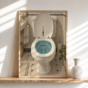 Può includere: Una stampa artistica da parete incorniciata che raffigura un WC bianco in un bagno piastrellato. All'interno della tazza, un gruppo di figure in miniatura in costume da bagno forma un cerchio, mentre un'altra si tuffa dal coperchio aperto.