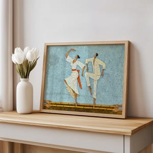 Light blue Filipino Tinikling Art Print styled on shelf, framed leaning against wall beside minimal white vase