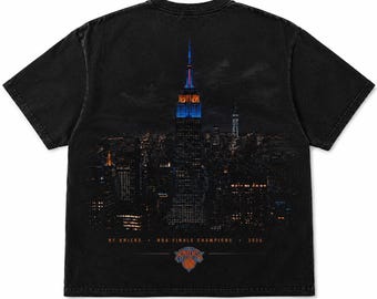 Camiseta de los New York Knicks campeones de las Finales de la NBA 2026, con el horizonte de Nueva York y el Empire State Building, color negro y colores cómodos.