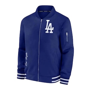 以下が含まれることがあります： 胸に白い「LA」ロゴが入ったロイヤルブルーのボンバージャケット。 ジャケットはジッパー開閉、左袖に小さなジッパーポケット、白と青のストライプの袖口と裾が付いています。 「Los Angeles」の文字は白で書かれています。