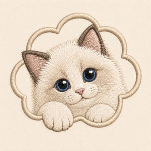 May include: An embroidery design featuring a cream-colored kitten with dark brown ears and bright blue eyes. The kitten is framed by a tan, cloud-shaped outline, with its front paws resting on the bottom edge of the frame against a light background.