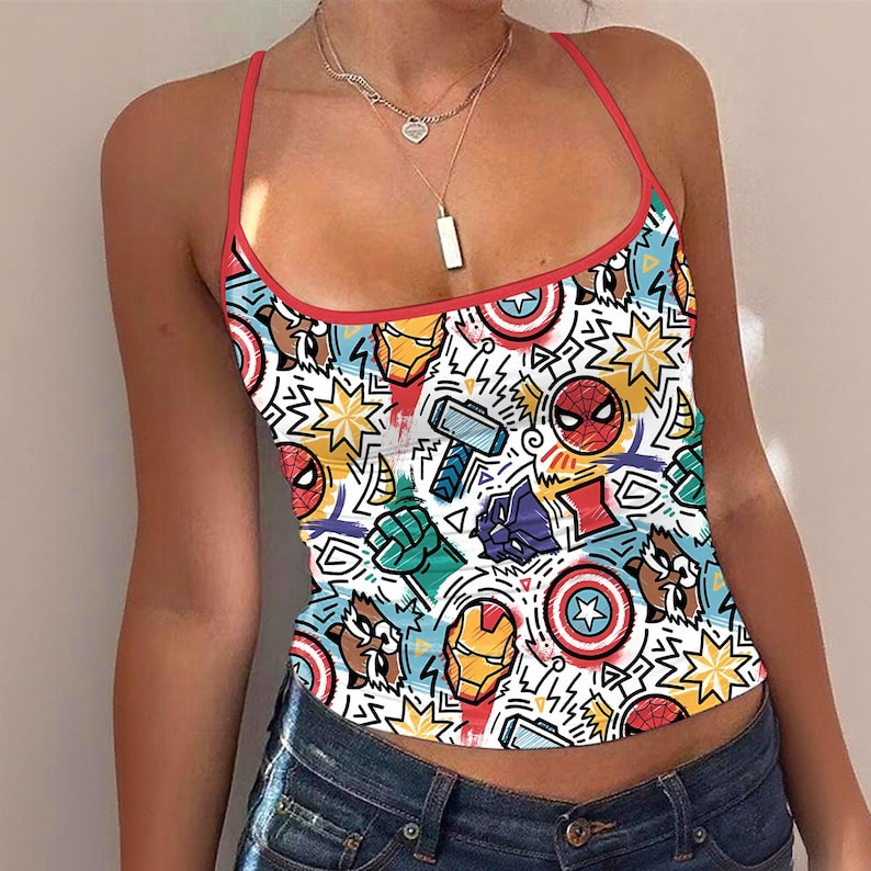 K&ouml;nnte beinhalten: Ein wei&szlig;es Tanktop mit rotem Besatz und Tr&auml;gern, das mit einem farbenfrohen Muster von Comicfiguren verziert ist. Das Design umfasst Spider-Man, Iron Man, Thors Hammer und Captain Americas Schild.
