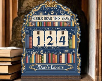 May include: A navy blue wooden bookshelf-shaped display with the text "BOOKS READ THIS YEAR" and the number "124". The display has a gold trim and a shelf of colorful books. The bottom reads "Mark's Library".