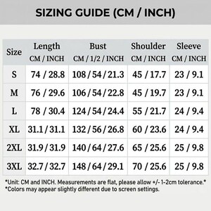 May include: A sizing guide chart with black text on a white background. The table lists sizes S through 3XL with corresponding length, bust, shoulder, and sleeve measurements in centimeters and inches. Includes a disclaimer about measurement tolerance.
