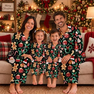 May include: Matching black long-sleeve button-down pajamas featuring a festive holiday print of gingerbread cookies, nutcrackers, Santa Claus, candy canes, and holly leaves. The set includes collared shirts and pants with white piping trim.